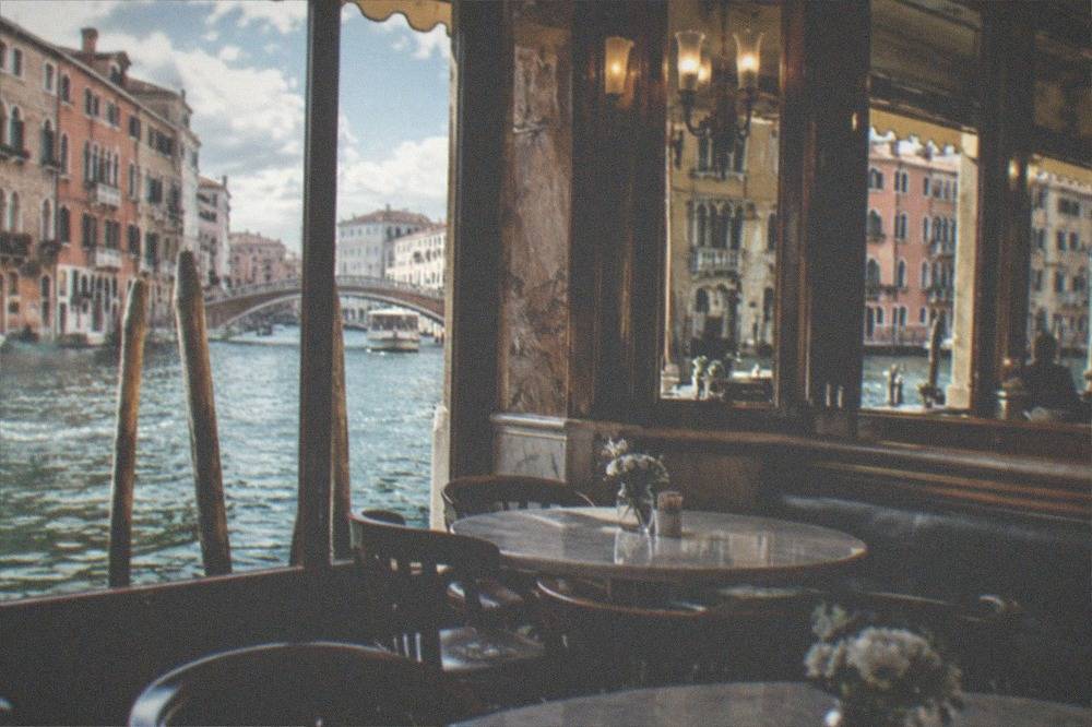 An elegant historic cafe interior with marble tables and mirrored walls