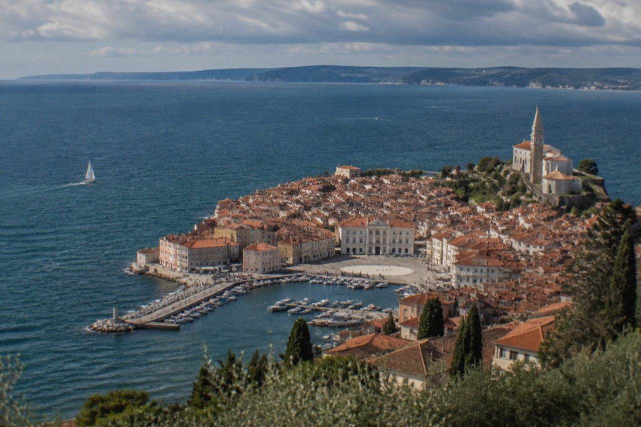 The Slovenian coast near Piran seen from the hills above the Adriatic, with red rooftops and a small harbour below