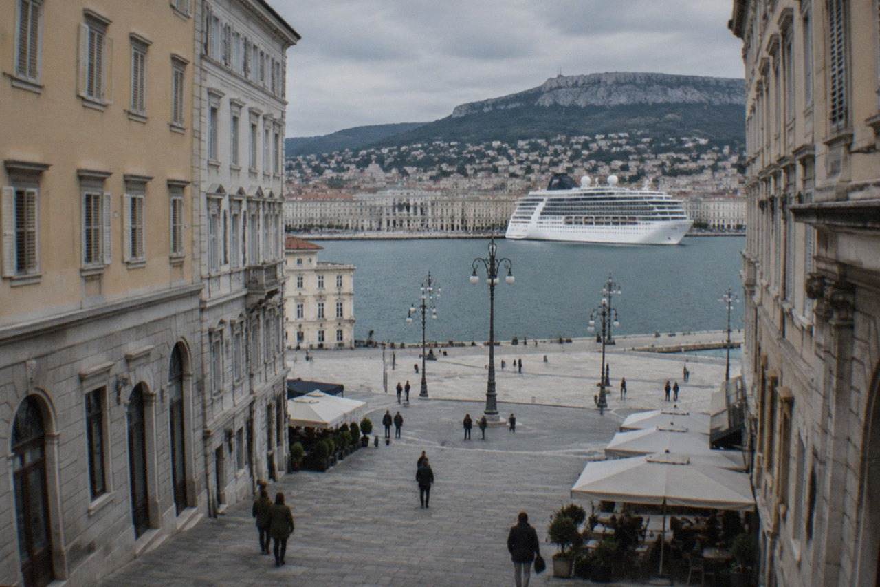 A cruise ship moored at the Trieste waterfront with the seafront piazzas of the city behind it
