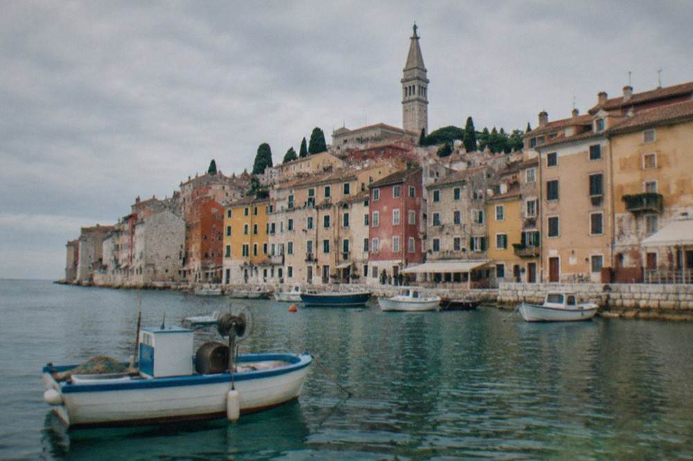 A boat resting in shallow water near a coastal town on the northern Adriatic