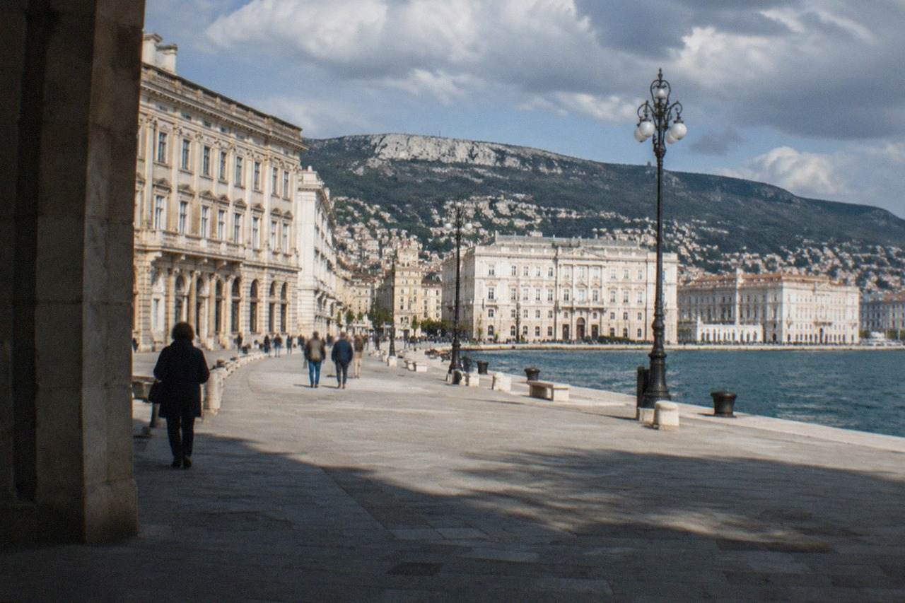 Grand neoclassical buildings facing the sea on a wide square in Trieste, Italy