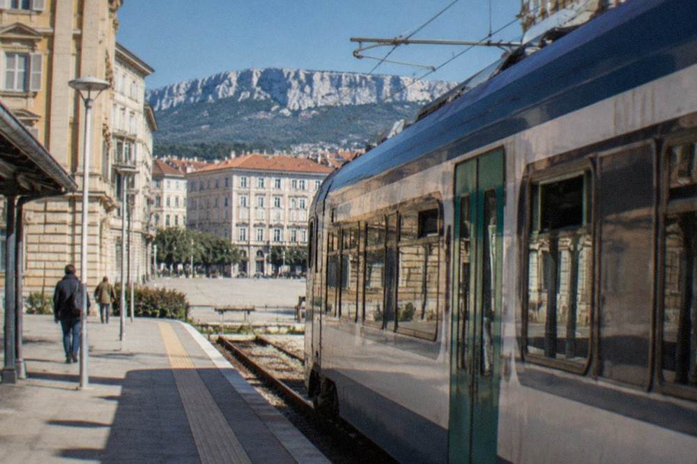 A regional train waiting at a small airport railway station platform