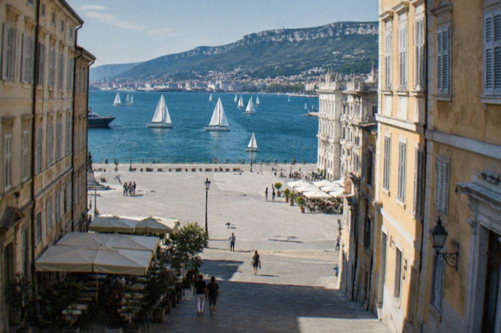 Sailing boats racing on the Gulf of Trieste in front of the city seafront