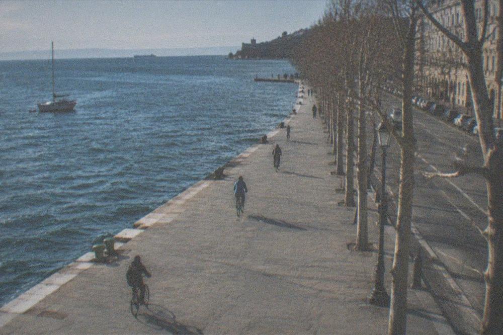 Cyclists on the flat seafront promenade at Barcola with the sea on one side