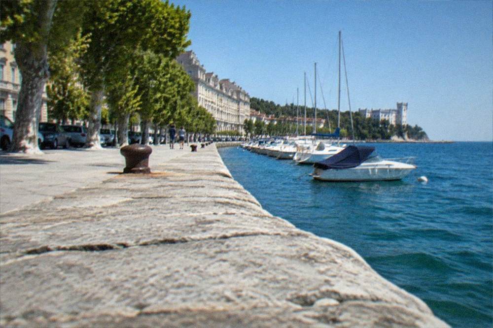 The seafront promenade at Barcola leading north toward the white silhouette of Miramare Castle
