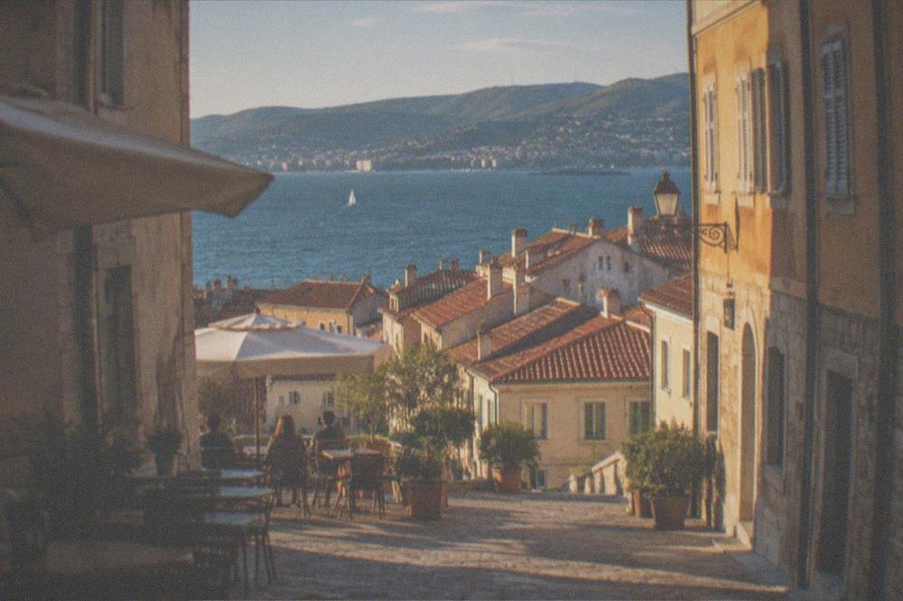 View over the rooftops of the Cavana district toward the sea and the hills beyond Trieste