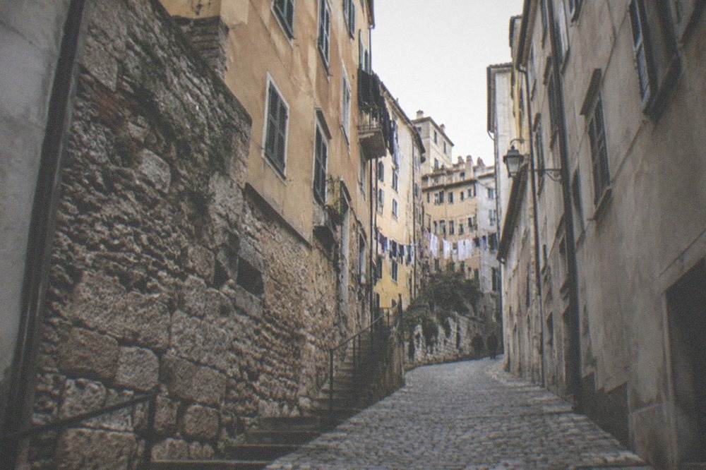 Cobblestone lane with old stone buildings curving up the hillside in the old town