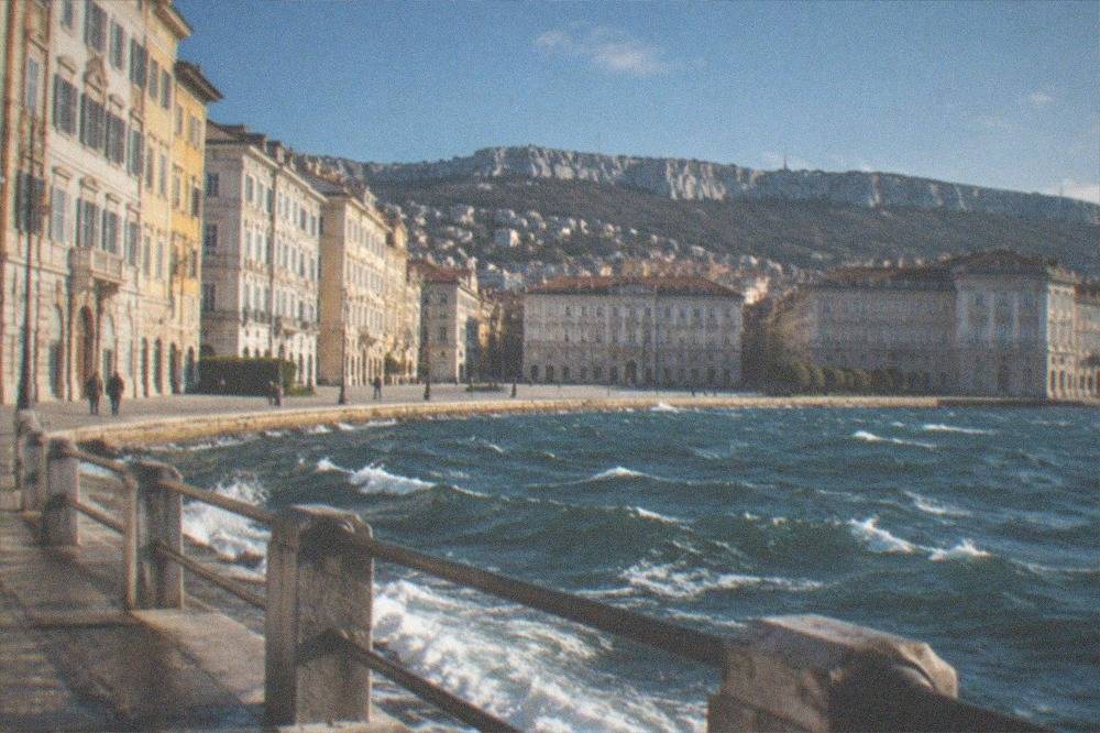 Whitecaps on the Gulf of Trieste seen from the seafront during a strong wind, with the promenade railing in the foreground
