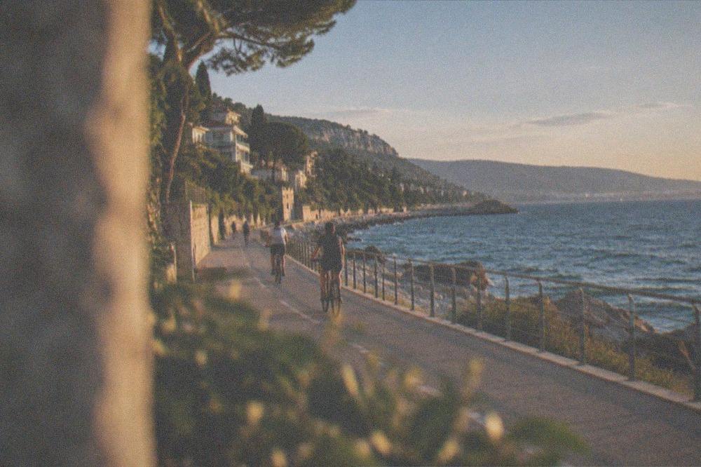 Cyclists riding along the seafront path at Barcola with the Gulf of Trieste on one side