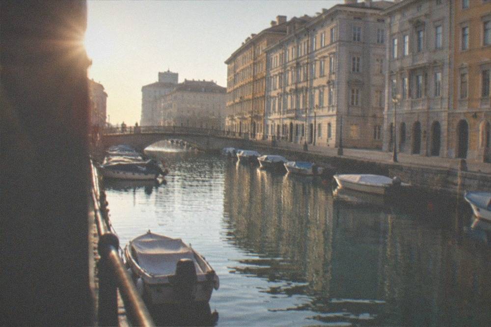 A bridge crossing a narrow city canal with historic facades on both banks