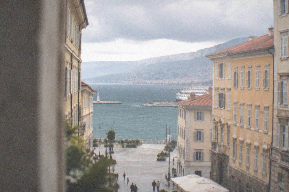 Rain clouds over the rooftops and seafront of Trieste seen from a high viewpoint