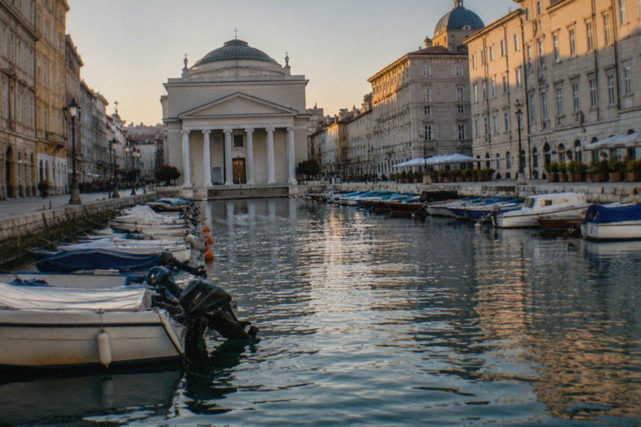 The Grand Canal in Trieste with boats moored along the banks and the church of Sant'Antonio Taumaturgo at the far end