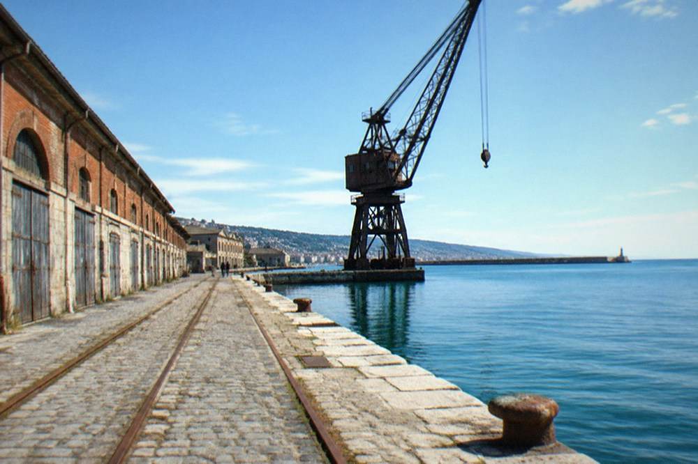 A harbour crane silhouetted against the sea at the old port of Trieste