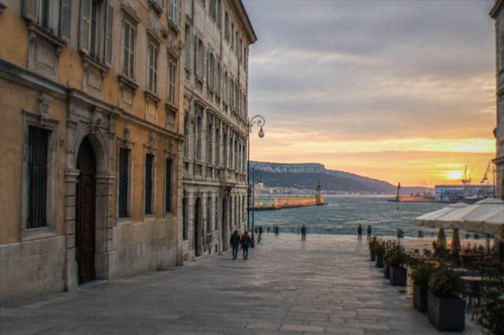 Sunset light on the old harbour walls and water of the Gulf of Trieste