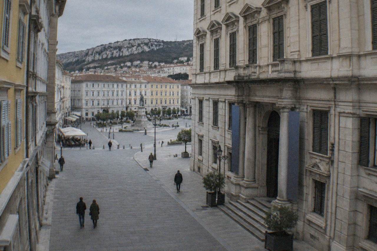 A stately 19th century palace facade on a Trieste street with the museum entrance visible