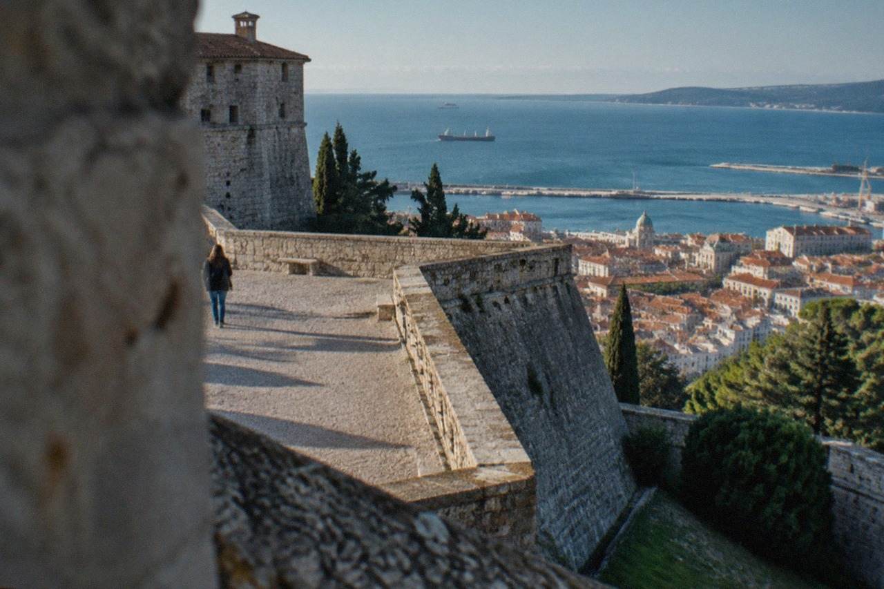 The ramparts of San Giusto Castle in Trieste seen from the hill, with the city rooftops and Adriatic sea below