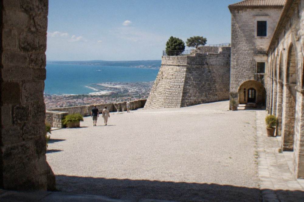 The interior courtyard of San Giusto Castle with stone walls and arched walkways
