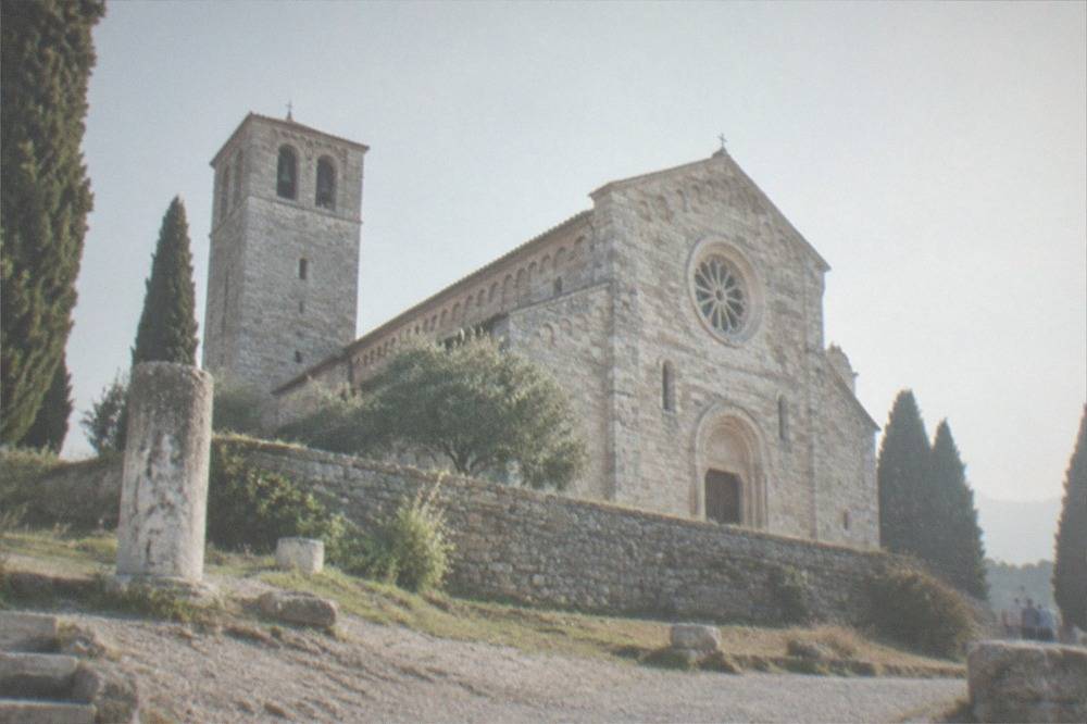 The cathedral's Romanesque facade and rose window in afternoon light