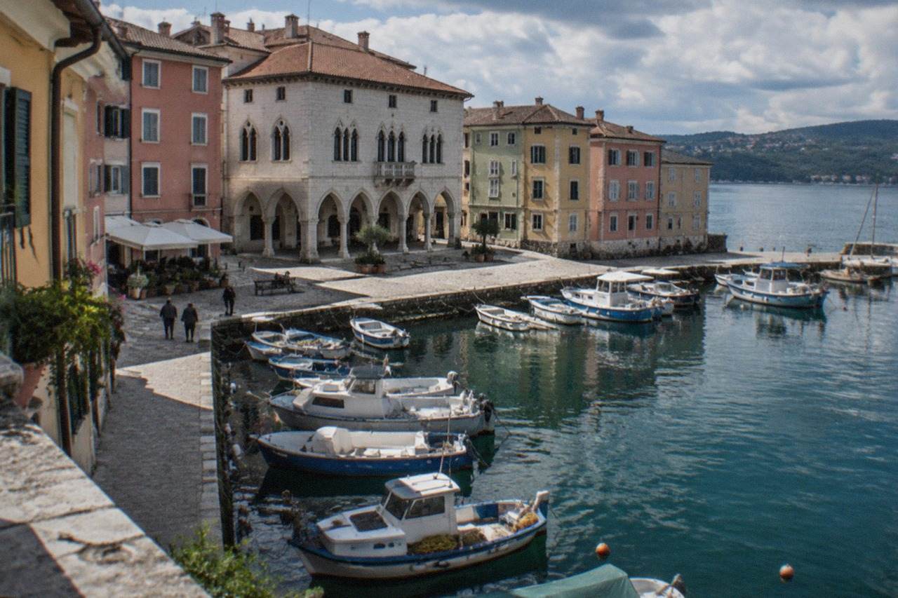 A small Italian harbour town on a sheltered bay with pastel houses and fishing boats