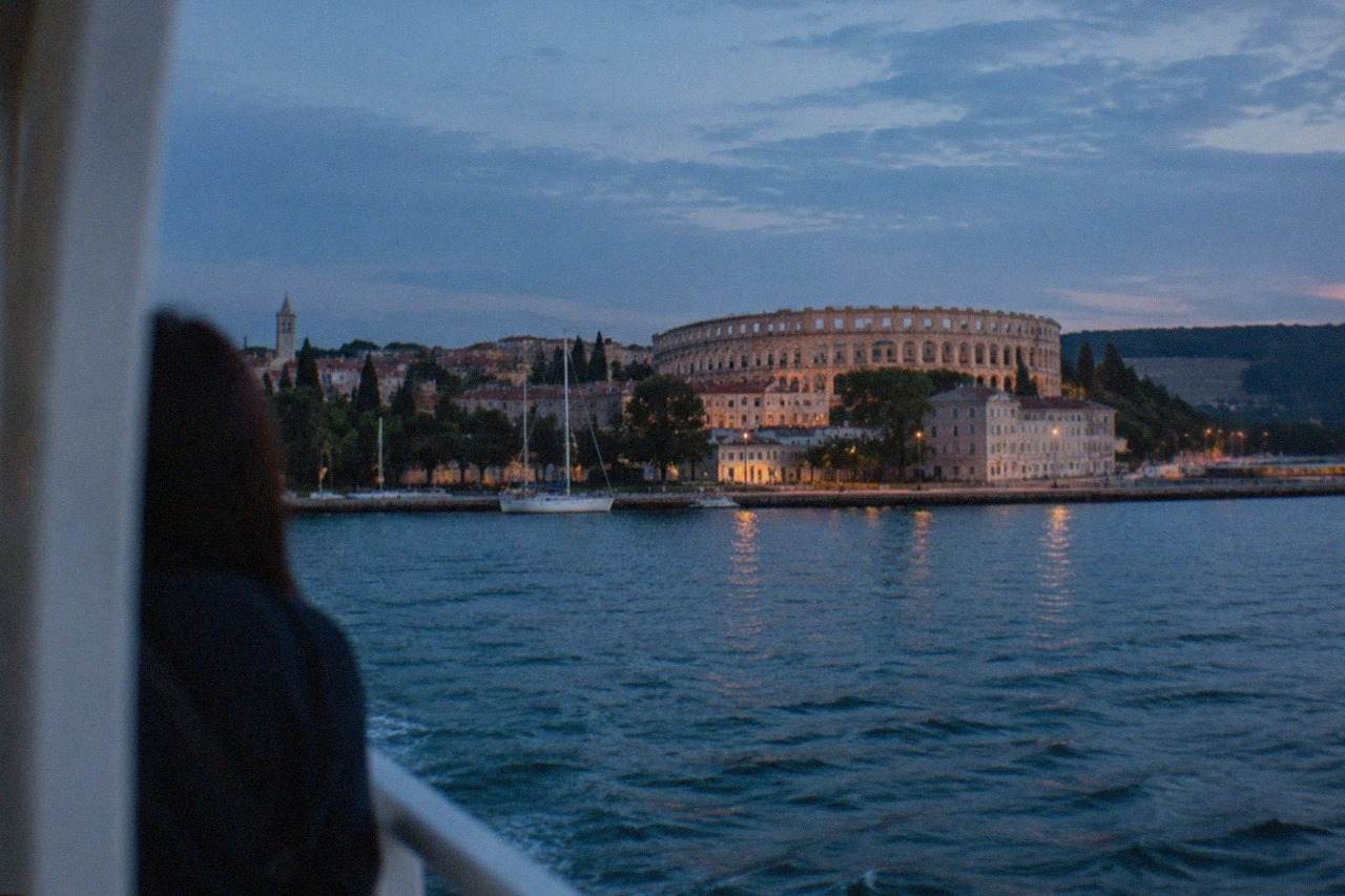 The historic centre of Pula in Croatia seen from the water, with the Roman amphitheatre visible on the headland