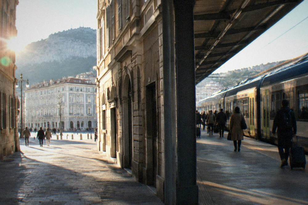 A regional train at Trieste Centrale station with passengers on the platform
