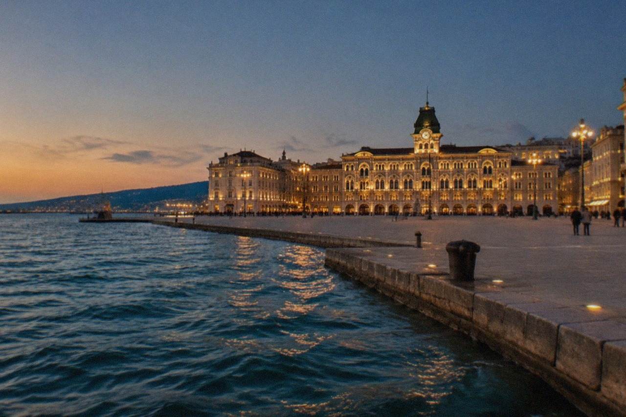 Evening view over Piazza Unità d'Italia and the Gulf of Trieste with the illuminated city hall