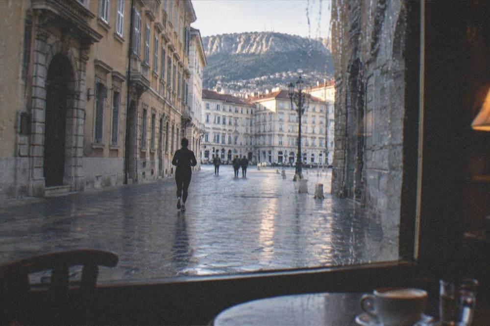 Evening light through the window of an old Trieste cafe with rain streaks on the glass