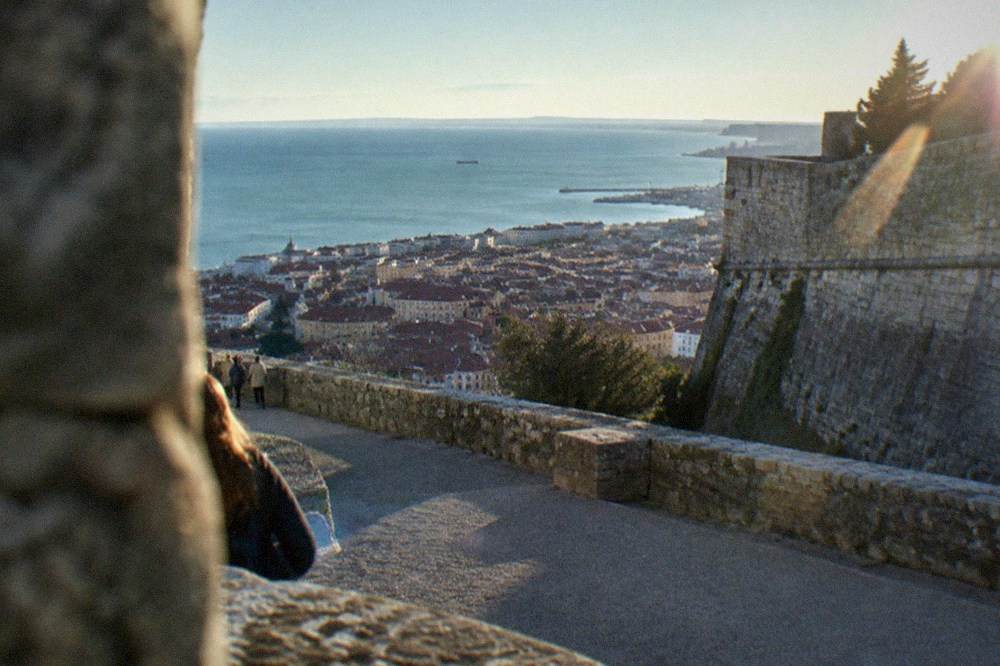 The ramparts of Castello di San Giusto above the rooftops of Trieste old town, with the Adriatic gulf in the background