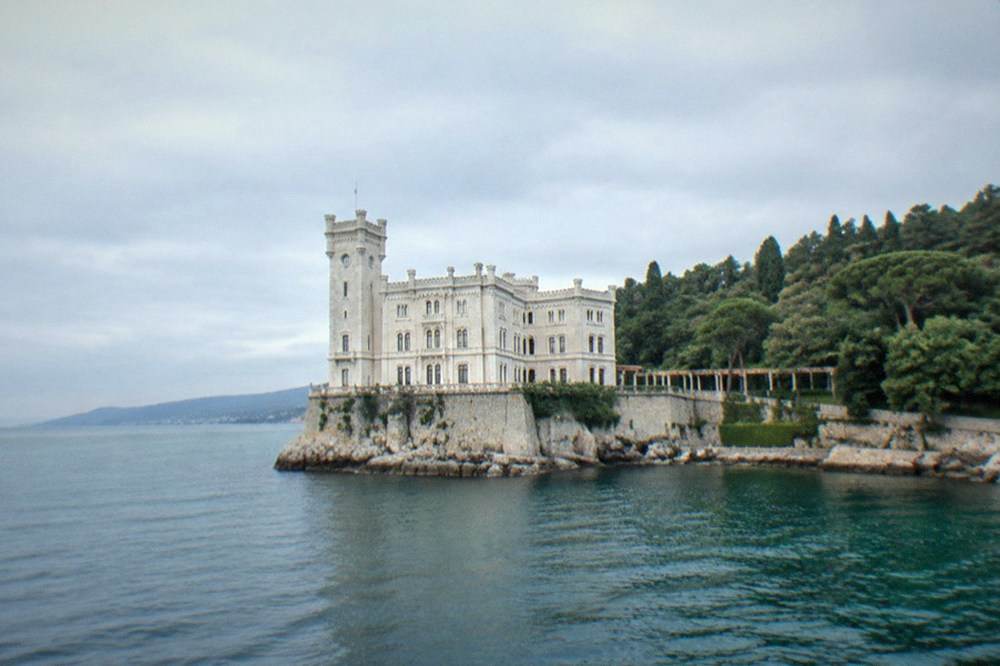The white walls of Miramare Castle above the sea and its wooded park on the Trieste coast