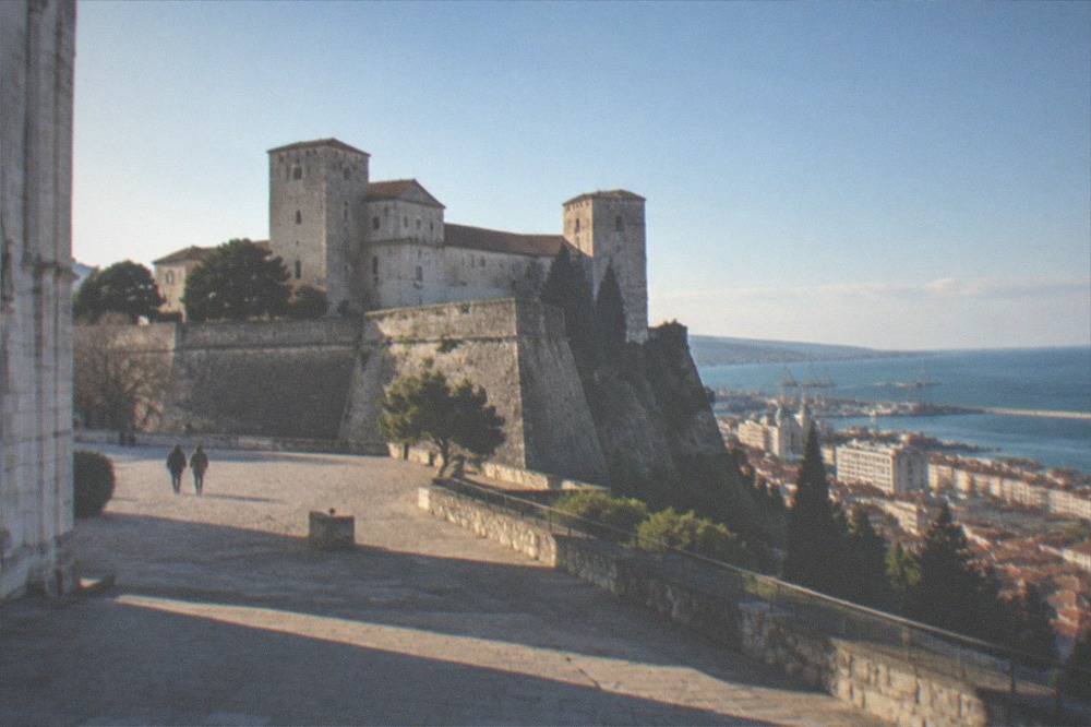 The walls and towers of Castello di San Giusto seen from the cathedral square in Trieste